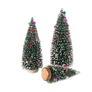 Miniature cedar trees with white flocking, colorful bells and natural wood bases for table