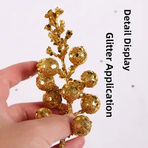 Macro shot of gold glitter Christmas berry pick showing sparkling coating detail