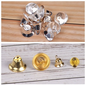 Macro shot showing golden and silver metal bells with top hanging loops for Christmas decor