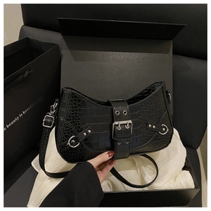 Detail of black crocodile texture baguette bag with silver buckles in luxury gift box