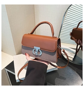 Detail of retro small square bag with brown leather and textured woven fabric texture