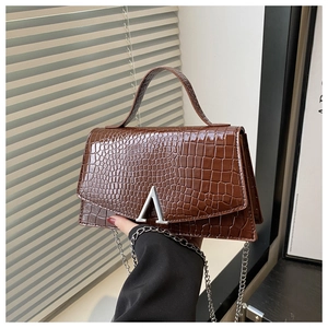 Close-up of brown crocodile texture leather bag featuring a silver A-shaped buckle