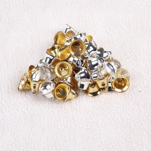 Golden and silver metal Christmas bells for tree decoration and DIY crafts on white fur