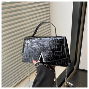 Detail showing shiny black crocodile embossed leather texture and silver A-shaped metal clasp