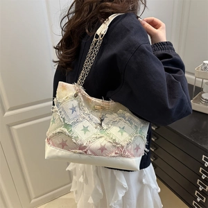 Stylish woven tote bag with fringe edge and gold chain strap shown on person