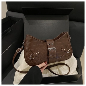 Detail of brown faux crocodile skin shoulder bag with silver buckle and vintage belt design