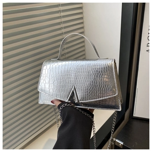 Detail of silver crocodile-pattern leather bag with a metallic V-shaped clasp and chain