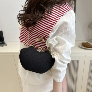 Elegant black heart-shaped saddle bag with gold handle and chain strap for women