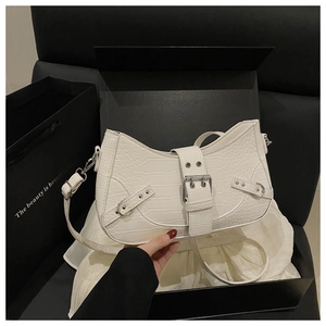 Detail of white crocodile embossed texture on shoulder bag with silver buckle accent