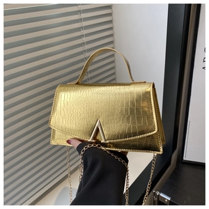 Detail of crocodile embossed leather texture and polished gold V-shaped buckle hardware