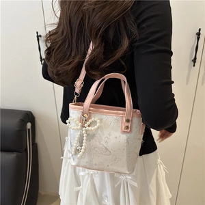 Borsa a secchiello rosa e bianca con motivo a farfalla e ciondolo di perle su modella