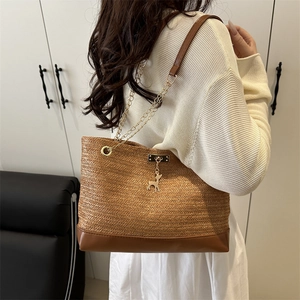 Fashionable straw tote bag with golden chain straps and a deer pendant charm
