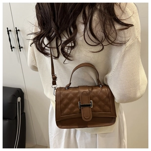 Gros plan du sac bandoulière matelassé marron avec boucle en métal et sangle réglable