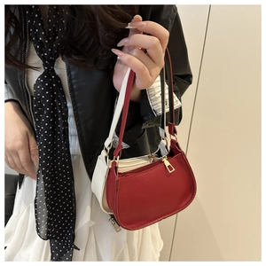 Detail of red and white pebbled leather crescent bags with gold zippers and fine stitching