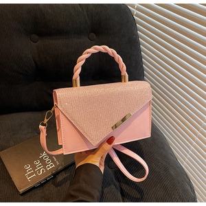 Vue détaillée du sac rose avec strass brillants et poignée anneau tressée élégante