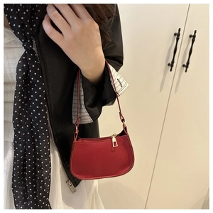Detail view of red lychee grain leather bag with a premium golden metal zipper