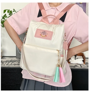 Rear view of women's beige nylon backpack with pink zippers and woven strap details