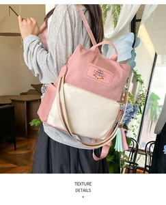 Pink and beige nylon backpack detail featuring decorative rabbit patch and tassel pendant