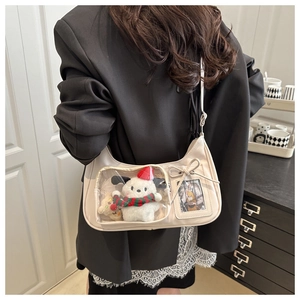 Detail of white PU leather tote bag with transparent window and plush animal charms