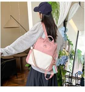 Detail view of pink nylon backpack with white pocket and Rabbit logo for women
