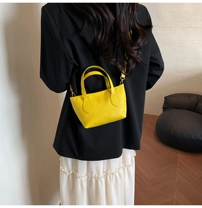 Detailed back view of a yellow lychee pattern tote bag worn cross-body style