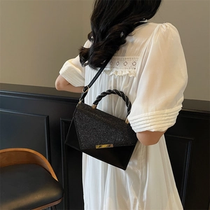 Sac à main noir élégant avec texture pailletée, poignée tressée et détails dorés
