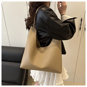 Detail of the litchi texture leather and metal eyelet on the khaki hobo tote bag