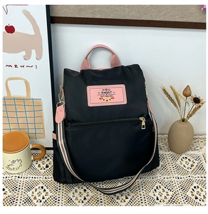 Detail of black nylon backpack with pink handles on a lace tablecloth and home decor