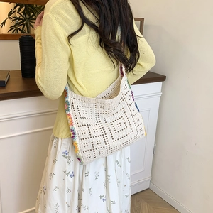 White crochet shoulder bag with colorful floral accents and geometric openwork design