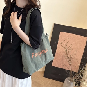 Sac fourre-tout en toile gris-vert avec lettrage orange pour le trajet quotidien