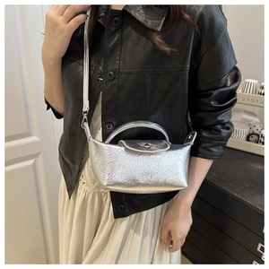 Close-up of silver dumpling bag with metallic pleated texture and top handle detail