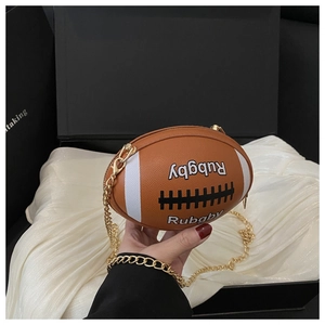 Detail of rugby-shaped brown faux leather bag with white stripes and gold chain strap