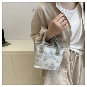 Close-up of mini butterfly print tote bag with gold hardware and drawstring lining detail