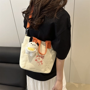 Canvas crossbody bag with orange straps and cartoon bear print shown in use