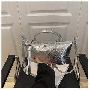 Close-up of metallic silver dumpling bag with pleated texture and adjustable strap