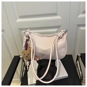 Détail du sac demi-lune rose clair avec fermeture éclair et charm d'ours en peluche
