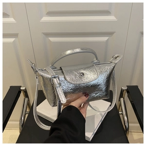 Close-up of silver metallic dumpling bag with pleated texture and adjustable strap