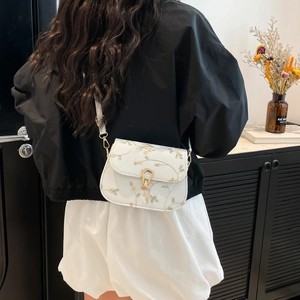 Sac bandoulière blanc avec broderie florale verte et boucle dorée en fer à cheval