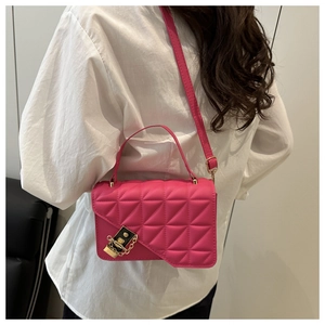 Detailed close-up of fuchsia quilted crossbody bag with gold padlock and chain
