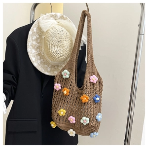 Detail of colorful handmade crochet flowers on a brown knit shoulder bag for women
