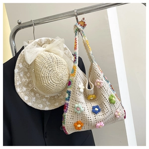 Close-up of handmade crochet bag with 3D colorful flowers and straw sun hat details