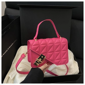 Detail view of fuchsia quilted crossbody bag with gold-tone buckle in elegant gift box
