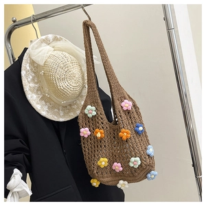 Detailed close-up of handmade crochet hobo bag with 3D colorful knitted floral accents