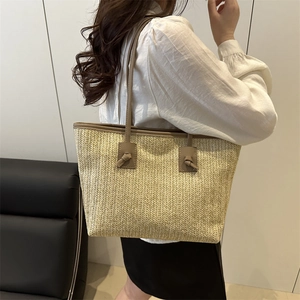Minimalist straw tote bag with brown leather handles for summer beach and casual vacations