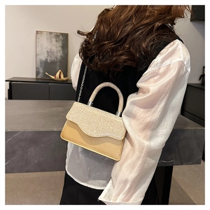 Detail of champagne gold square bag with sparkling rhinestones and chain strap