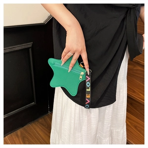 Detail of green star-shaped leather purse with colorful LOVE printed wristlet strap