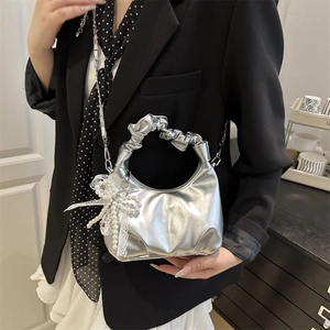 Silver metallic crescent bag with ruffled handle and lace bow decoration