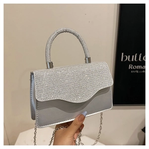 Detail of silver rhinestone evening bag with sparkling gems and metallic chain strap