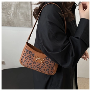 Détail du tissu léopard et de la boucle en métal doré sur un sac baguette chic