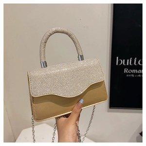 Macro shot of champagne gold evening bag with rhinestone-encrusted handle and flap detail